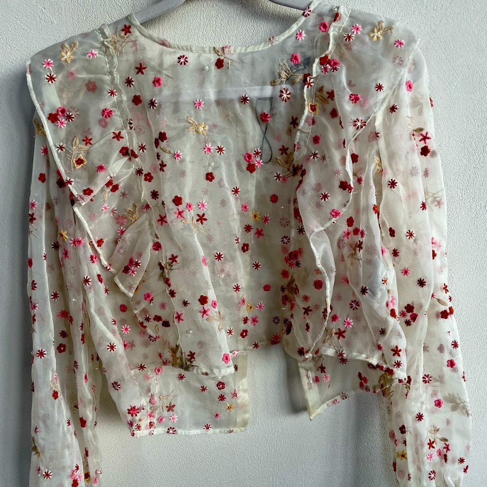 Embroidered,sheer, short too with long sleeves.Ruffles on the front,buttons back